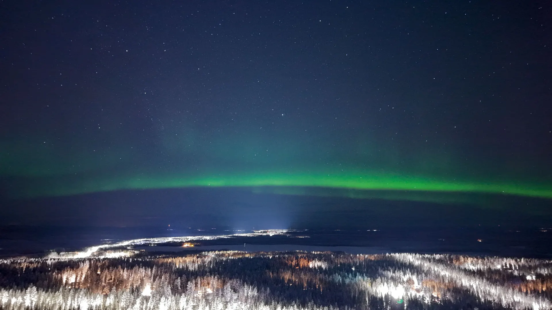 Moderni havaintolodge lumessa revontulitaivaan alla